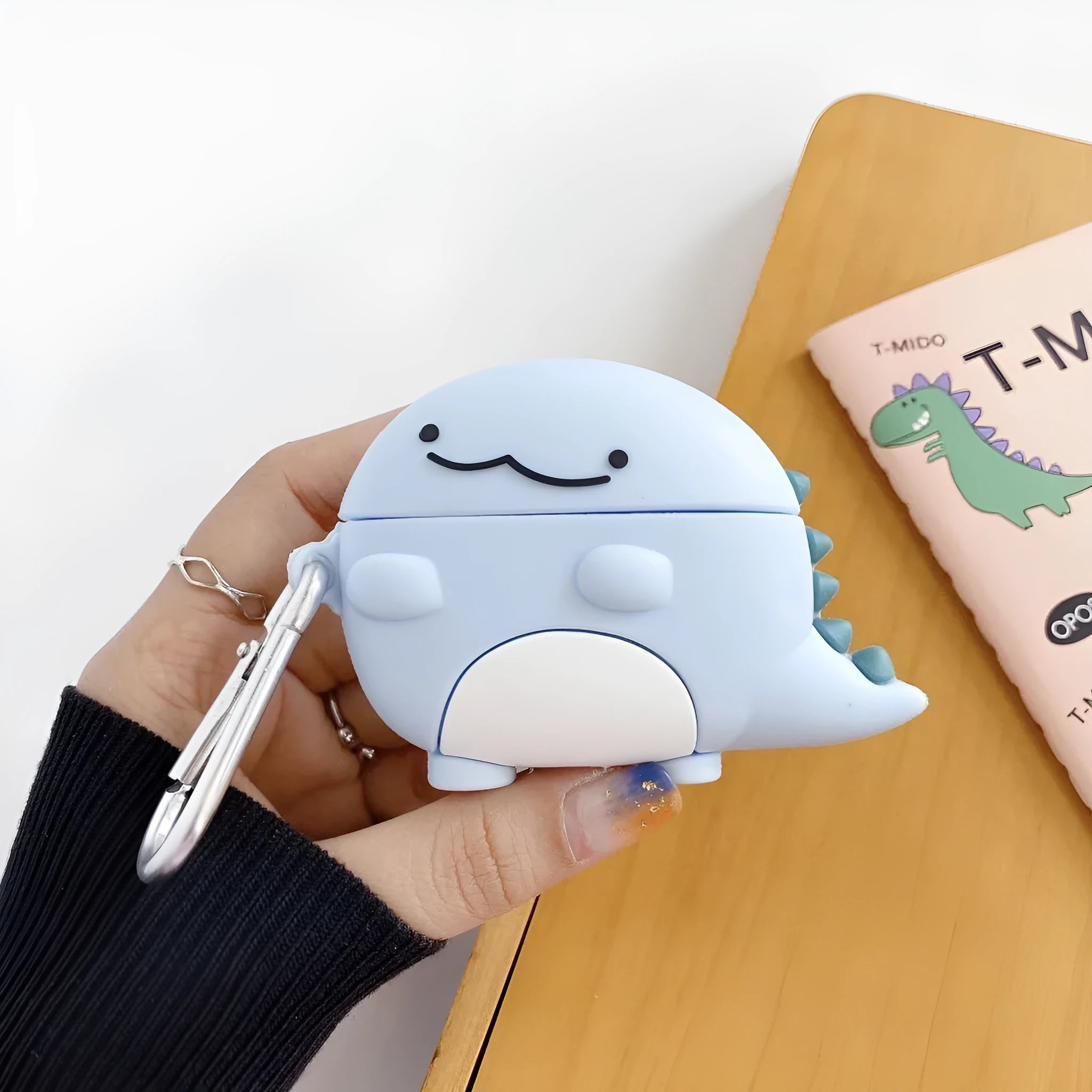 Blue silicone earphone case with a cute baby dragon design, fitting a single Apple AirPod.