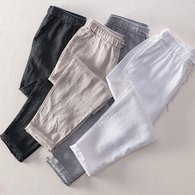 Men's straight-leg linen trousers in light gray shown laid flat.