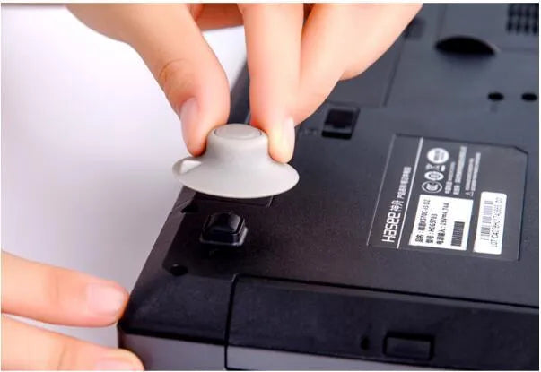 Four grey plastic laptop cooling pads, two large and two small, on a flat surface.