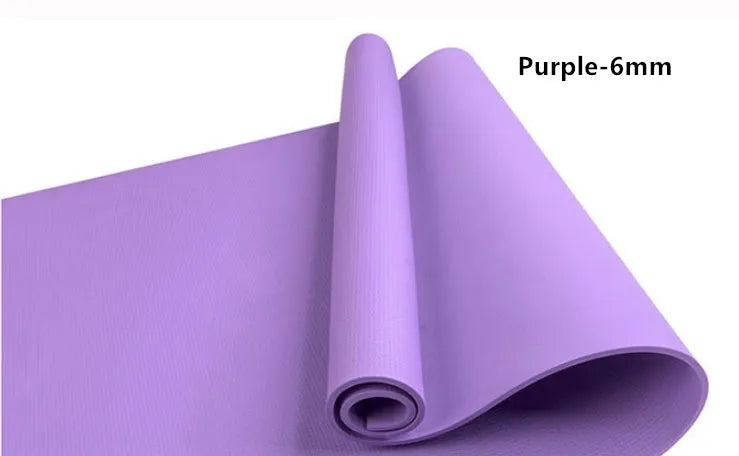 Red EVA fitness yoga mat with rolled edge showing thickness, laid flat on a wooden floor.