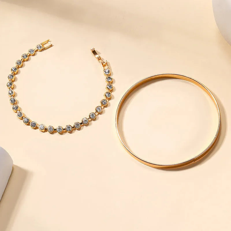 Two vintage drop-shaped geometric bracelets in gold and silver, side by side