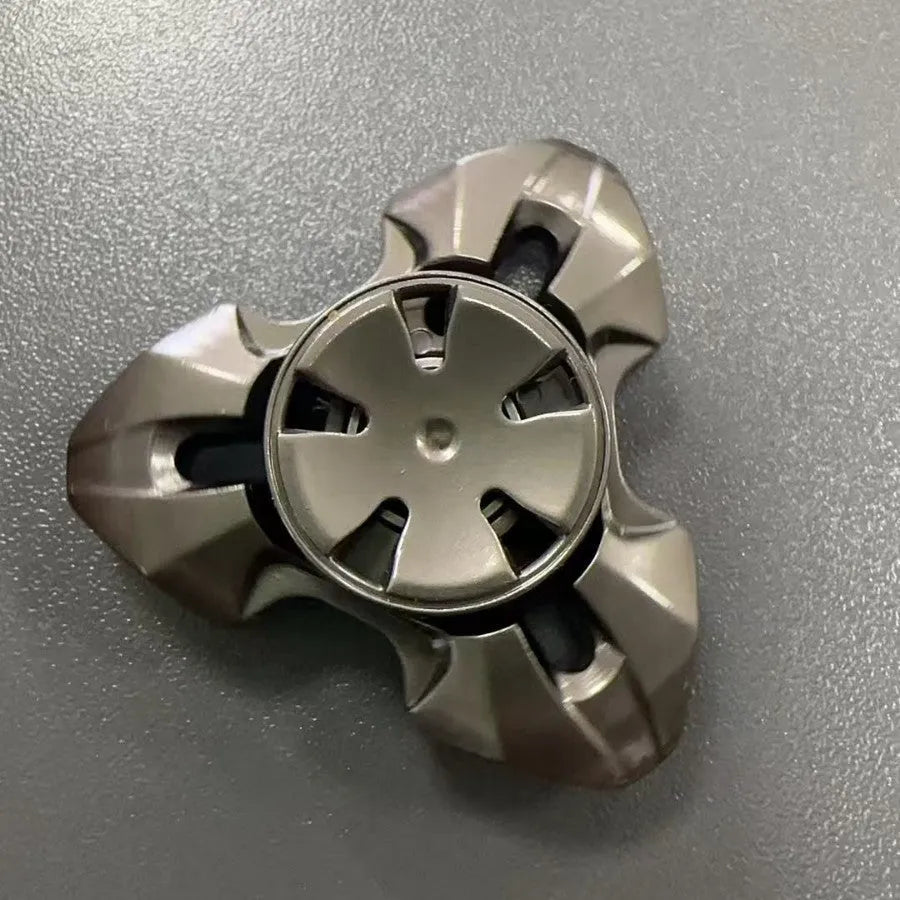 Close-up of a metallic alloy rotating fingertip gyro decompression toy on a table.