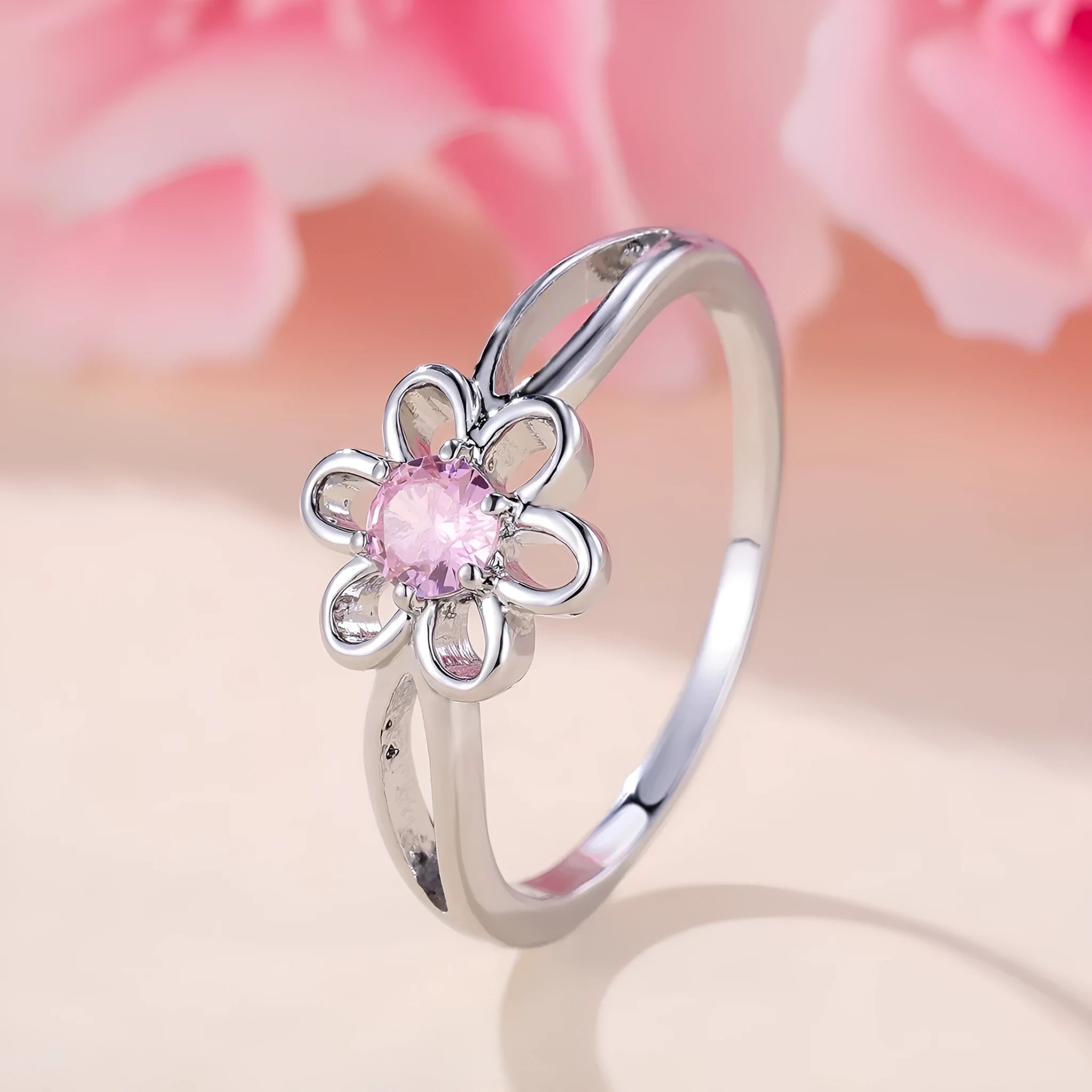Women's hollowed flower fashion ring in electroplated platinum pink diamond colour on a white background.