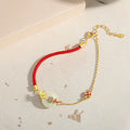 925 sterling silver red rope bracelet with a gold koi peace buckle safety clasp.