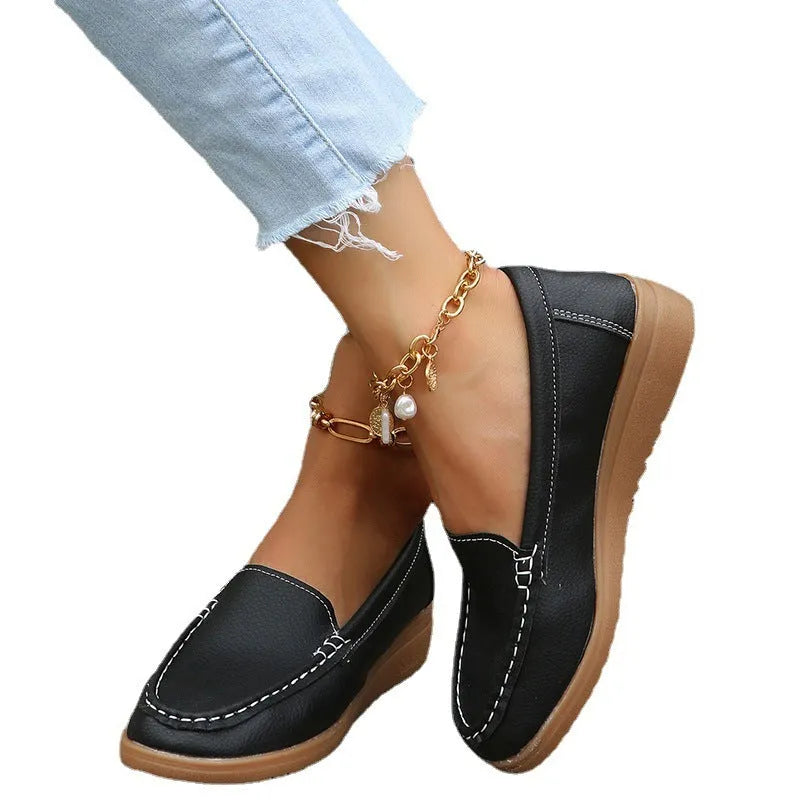 Women's black PU leather flat loafers with round toe and car suture design on a rubber sole.