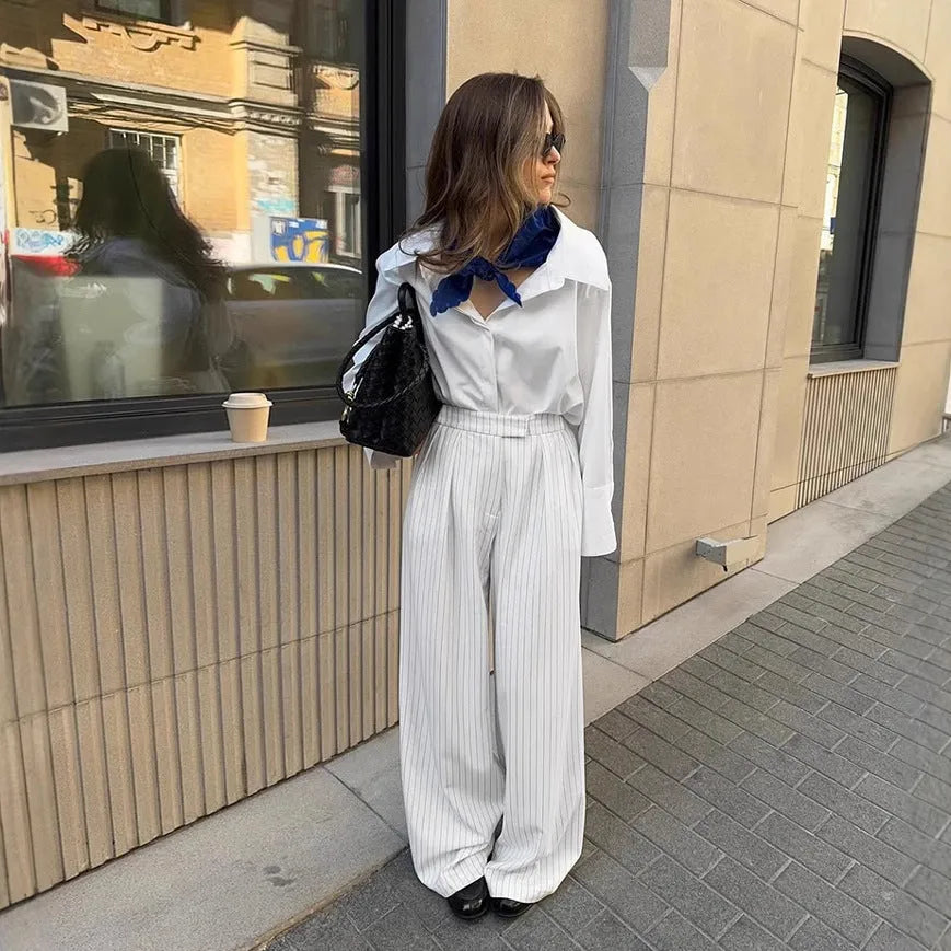White striped wide-leg casual trousers with a zipper fastening on a neutral background.