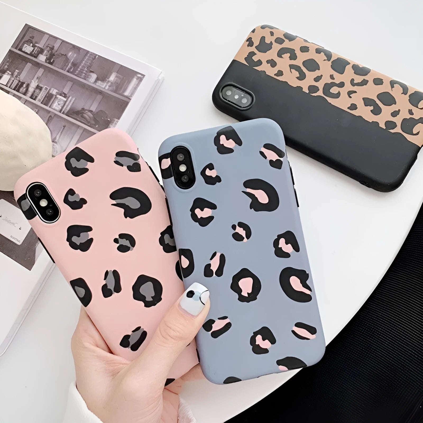 Leopard print mobile phone case for iPhone in black, blue, and pink colours
