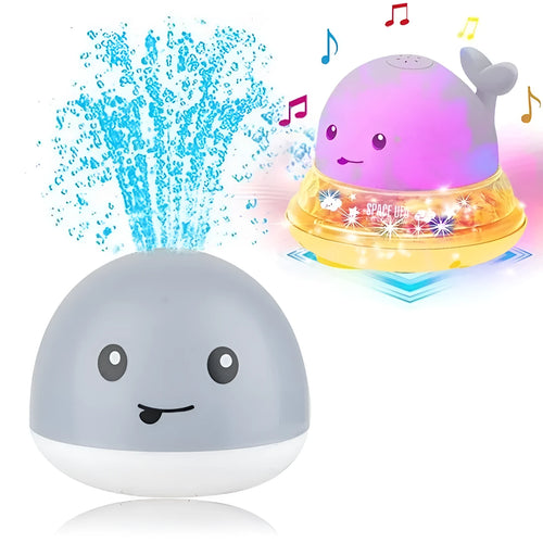 White and blue whale-shaped bath toy spraying water with LED lights on, floating in a baby bath