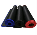 Solid colour locking edge large gaming mouse mat in black, 30x60 cm, on desk with keyboard and mouse