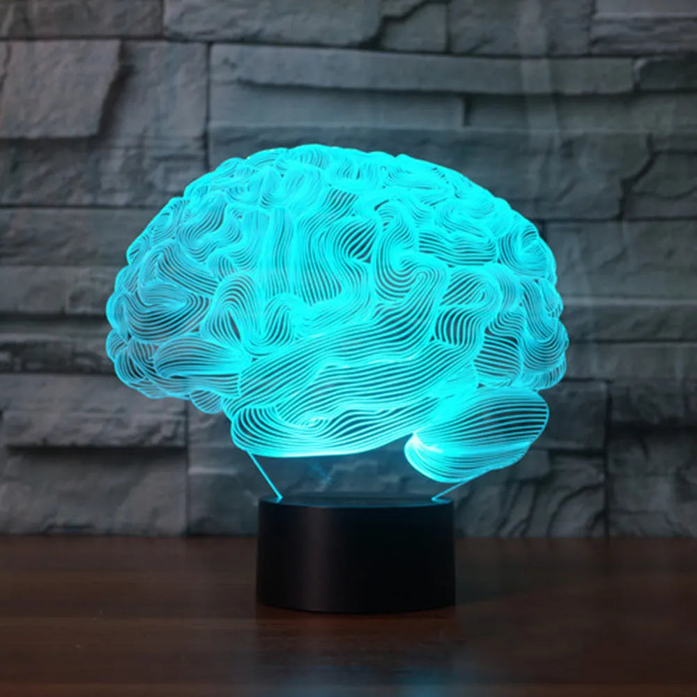 3D acrylic brain hologram LED desk lamp with black base and remote control on a wooden table.