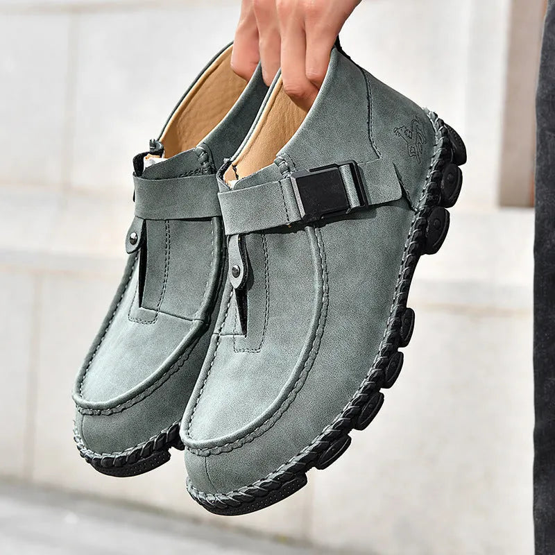 Casual flat slip-on shoes in black synthetic PU leather with visible handmade stitching around the sole.