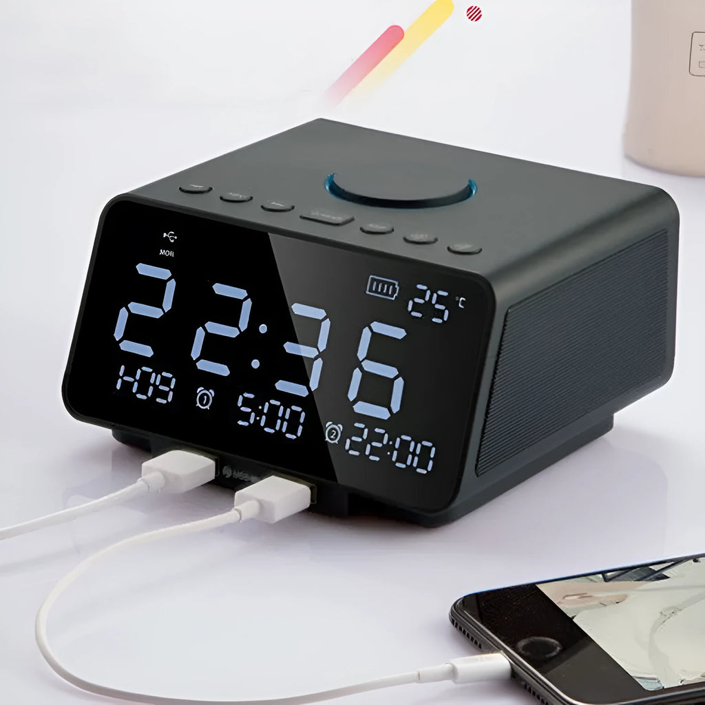 Black and white wireless alarm clock speaker with Bluetooth, radio, and USB playback functions on a bedside table.