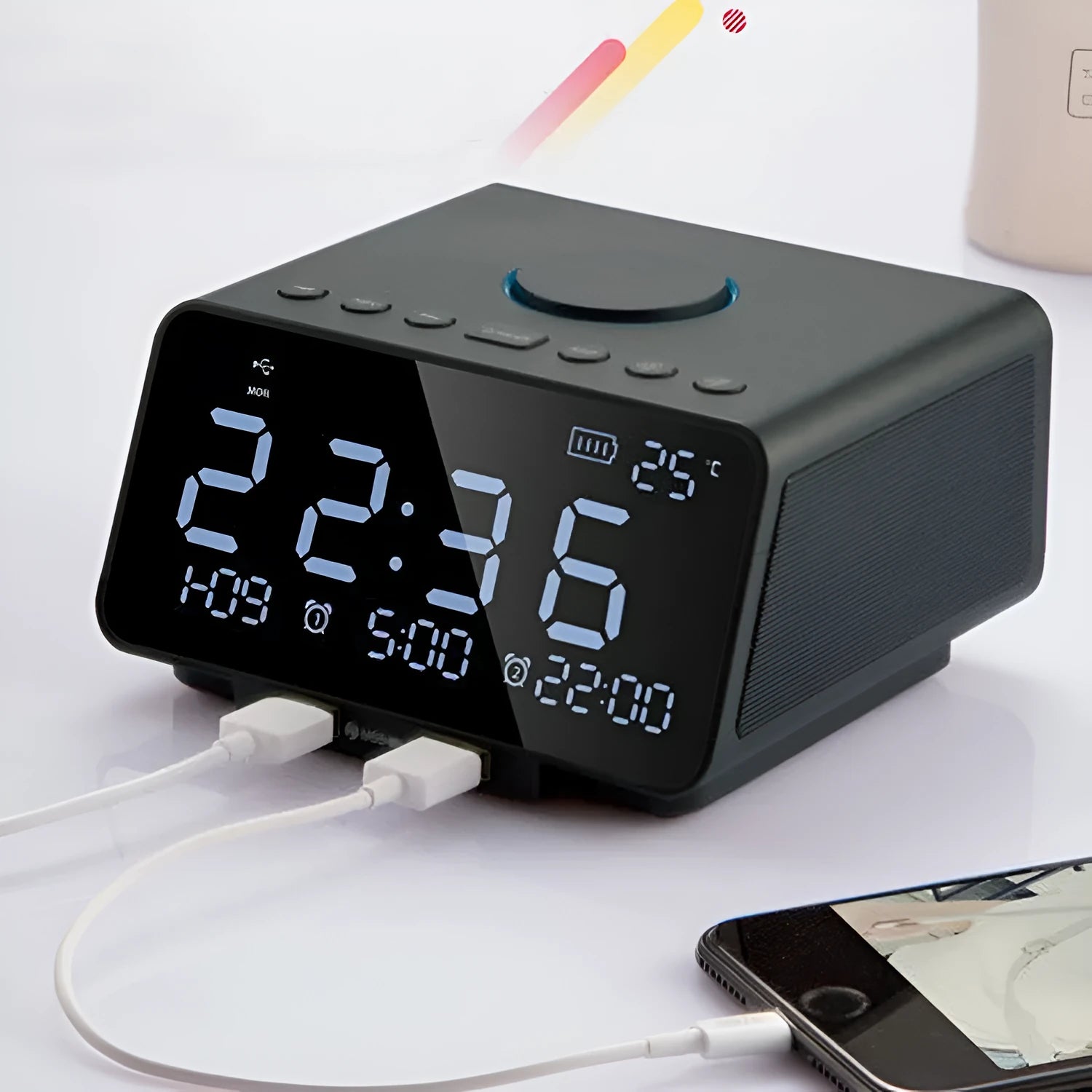 Black and white wireless alarm clock speaker with Bluetooth, radio, and USB playback functions on a bedside table.