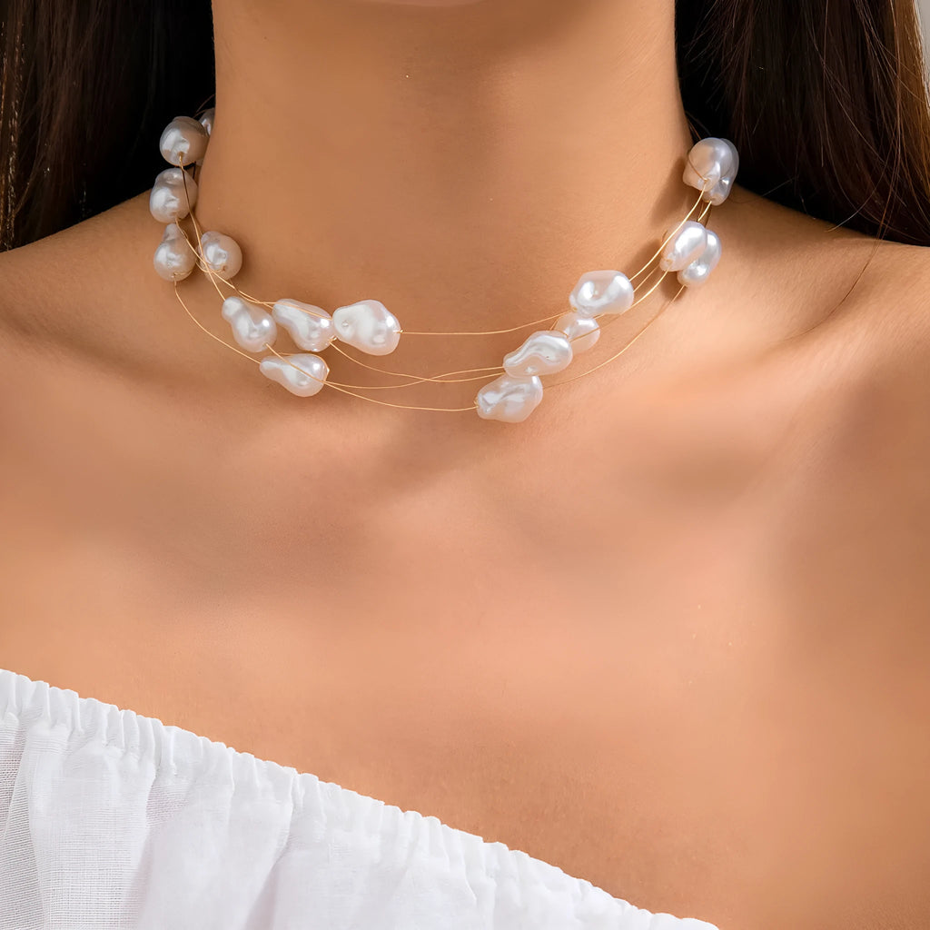 Gold-tone baroque imitation pearl necklace and bracelet set with U-shaped pendant on woman
