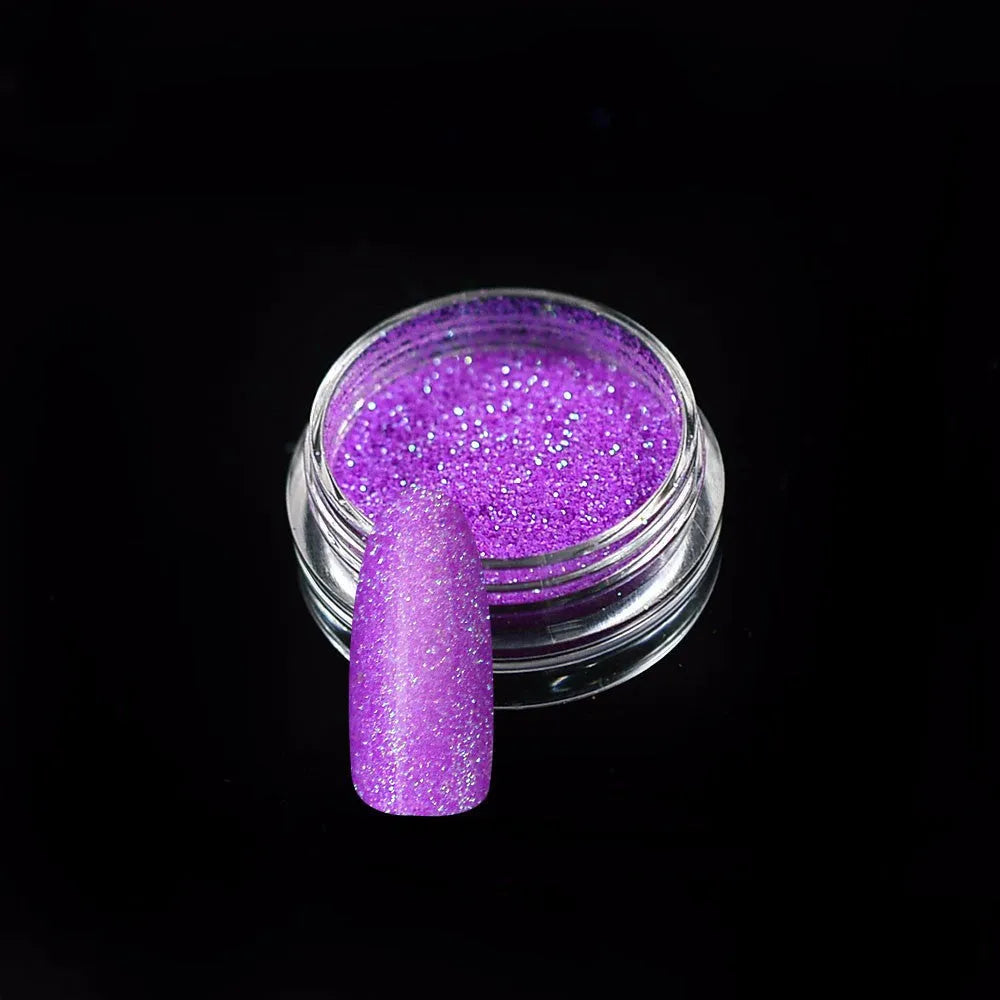 Six 1g pots of neon nail glitter powder in blue, green, orange, pink, purple, and yellow colours on a white background