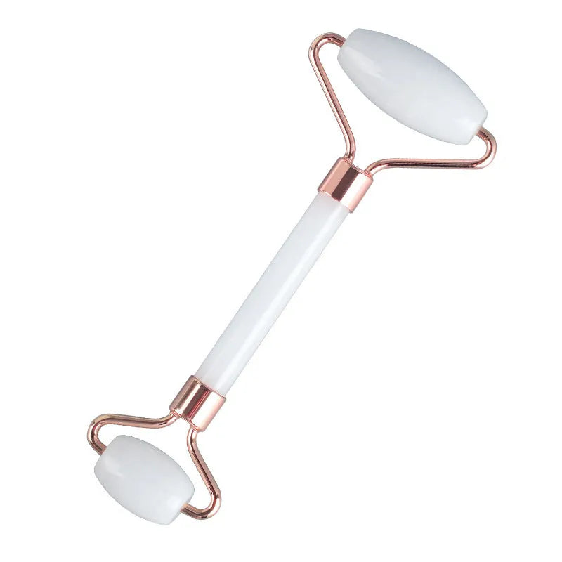White jade facial roller and gua sha tool set with rose quartz board on a neutral background.