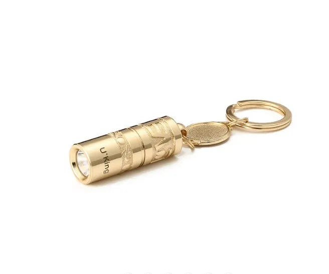 Gold-coloured zinc alloy waterproof mini LED flashlight on a keychain ring.