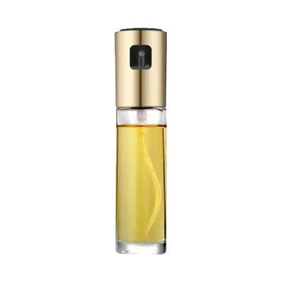 Gold pump-action oil and vinegar spray bottle with 100ml glass body on kitchen counter.