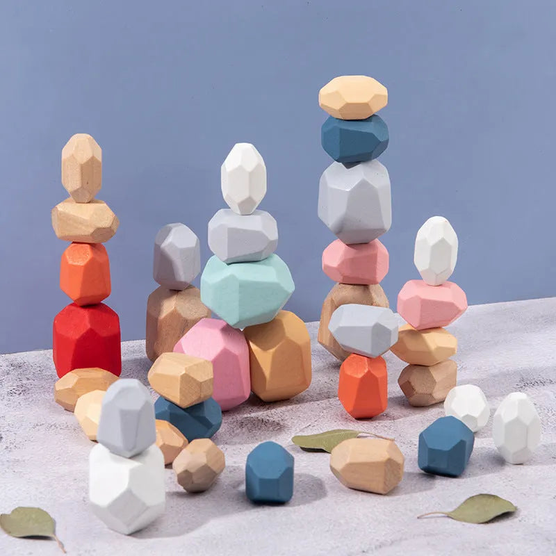 Wooden building block set with coloured and natural stone stacks on a table, suitable for children aged 4-6