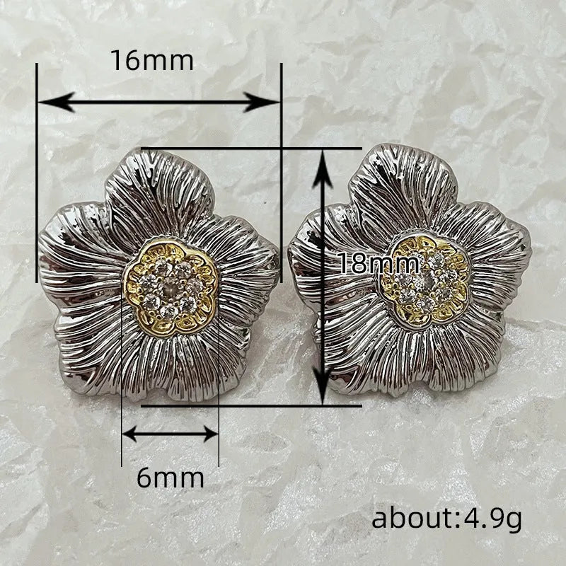 Close-up of women's copper stud earrings with a textured floral design in a two-tone colour.