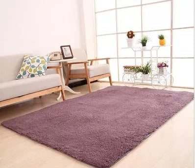 Solid colour plush carpet with soft surface and rectangular shape on hardwood floor