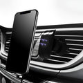 Black car phone holder mounted on vehicle air vent with phone in cradle
