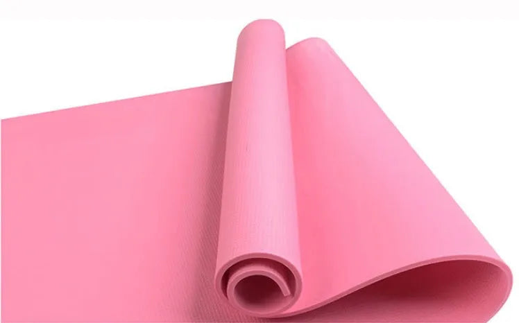 Red EVA fitness yoga mat with rolled edge showing thickness, laid flat on a wooden floor.