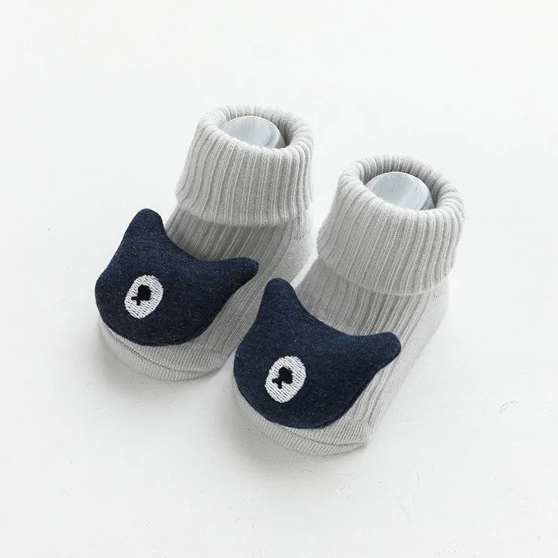 Baby socks with non-slip rubber grip soles on the feet, shown in a light grey colour.