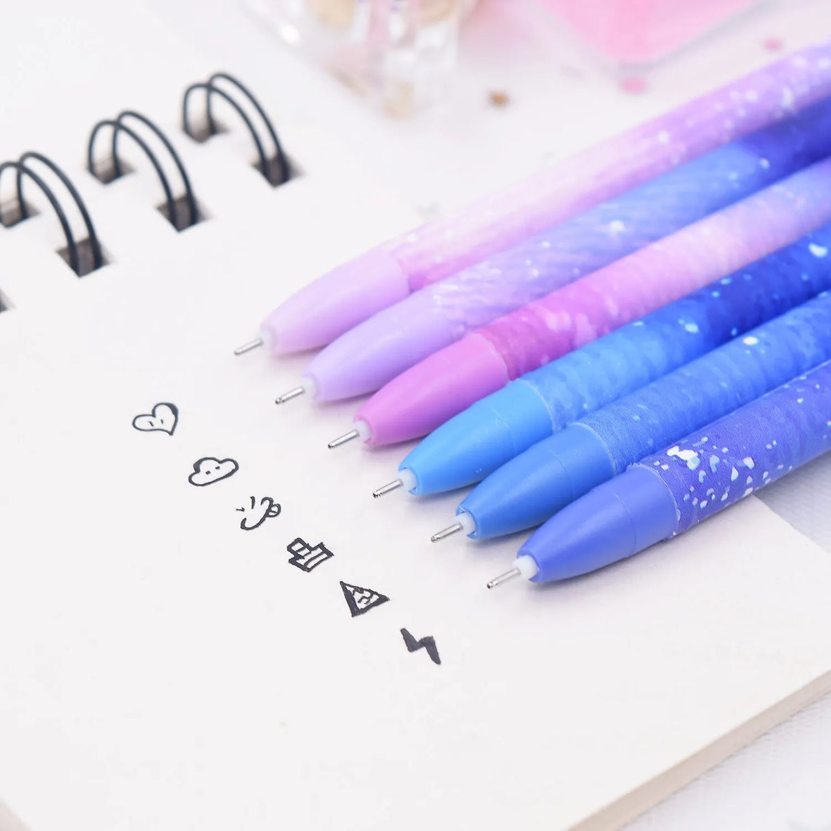 Box of 12 plastic gel pens with quick-drying ink and constellation-themed designs in assorted colours