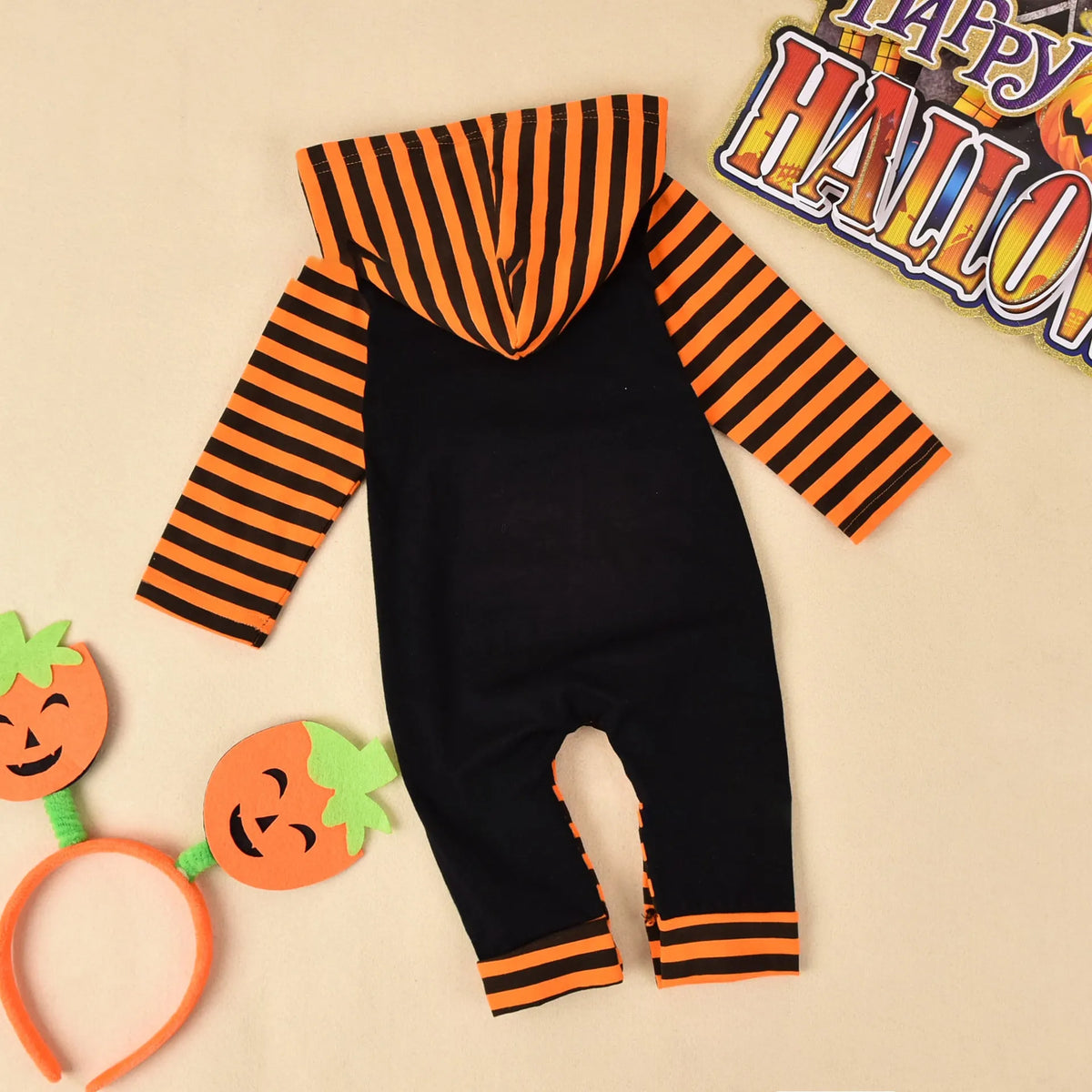 Halloween romper in black cotton with long sleeves and attached hood, shown on a neutral mannequin