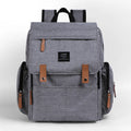 Land Mommy large oxford cloth diaper backpack in grey with a changing mat, shown open.