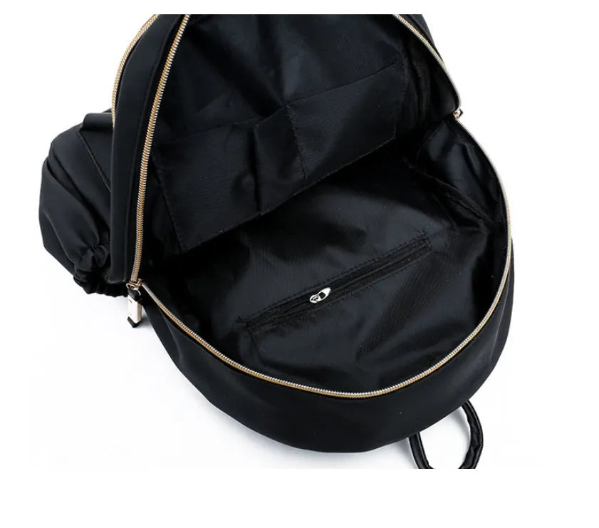 Black waterproof Oxford cloth backpack for women, 34x26x13cm, with two straps and front pocket on plain background