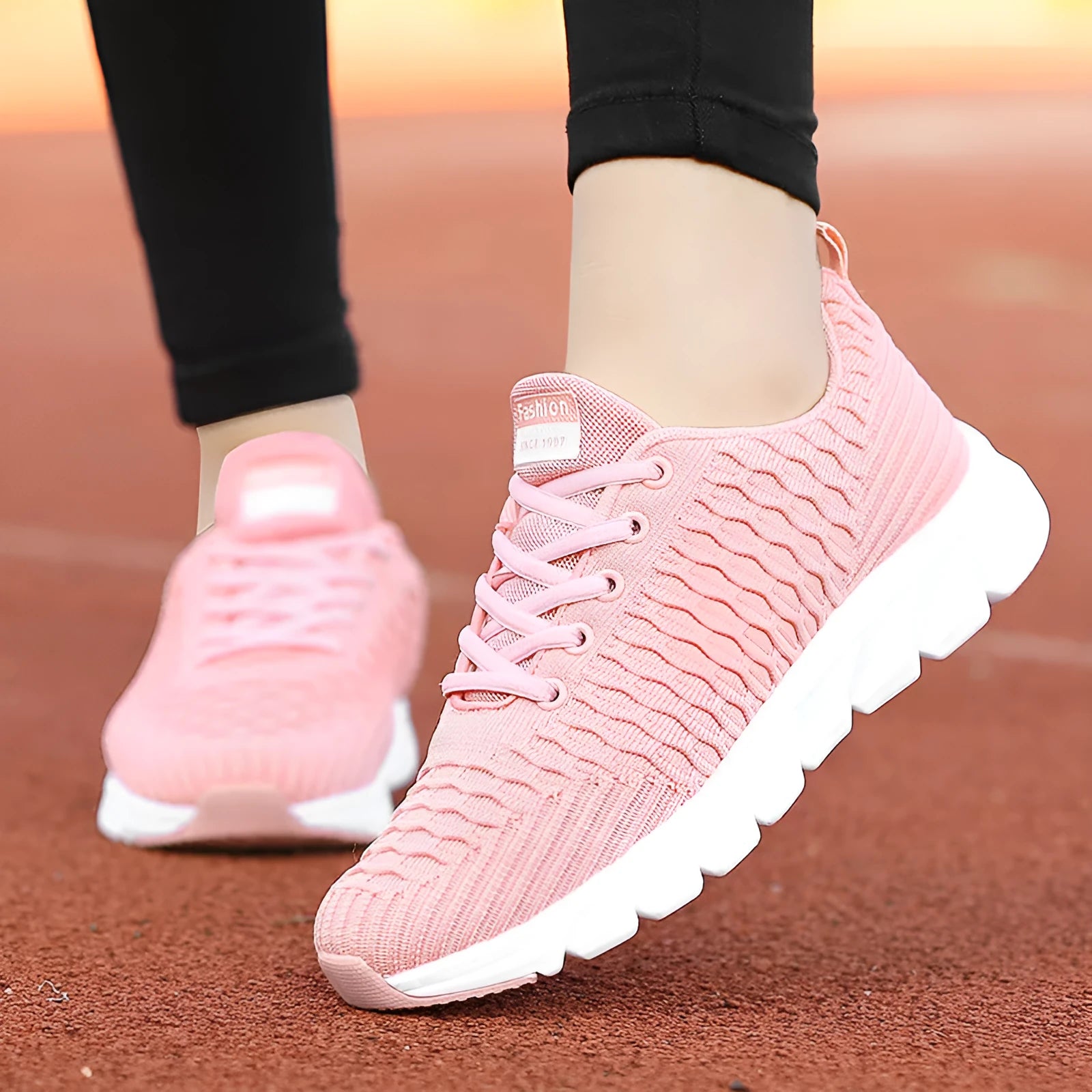 Women's running shoes in black, pink, or white with a fly-weave upper and durable outsole.