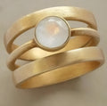 Gold-plated titanium steel geometric ring with a white chalcedony stone inset on a simple band.