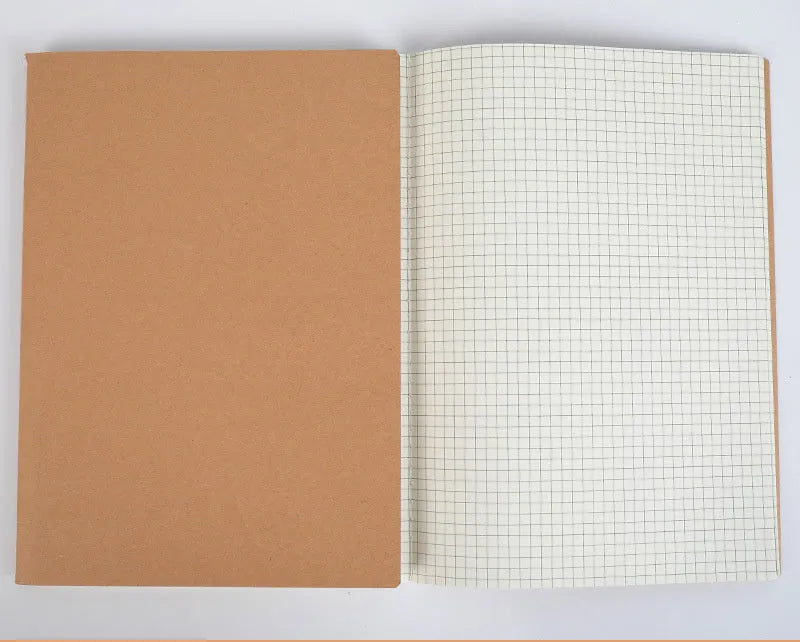 Softcover thread-bound notebook open on a table, showing flat-lay binding and lined paper.