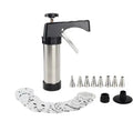 Stainless steel biscuit press gun with assorted cookie mould discs and icing nozzles on a baking tray.