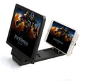 Black and white adjustable mobile phone stand with anti-radiation 3D screen amplifier on a desk.