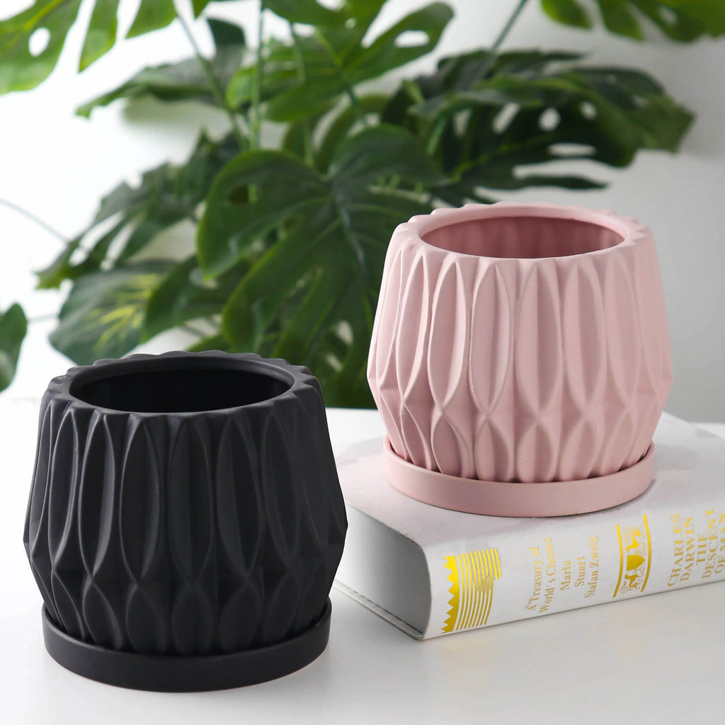 A simple grey ceramic flowerpot on a tabletop, medium sized for plants.
