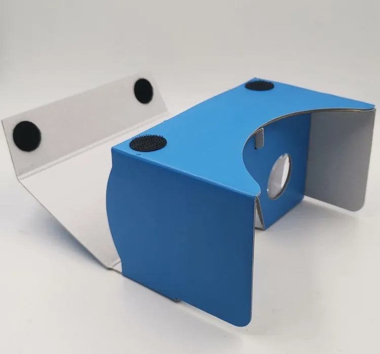 Pink and white foldable VR cardboard glasses for mobile phones, showing 3D lenses and rubber band.