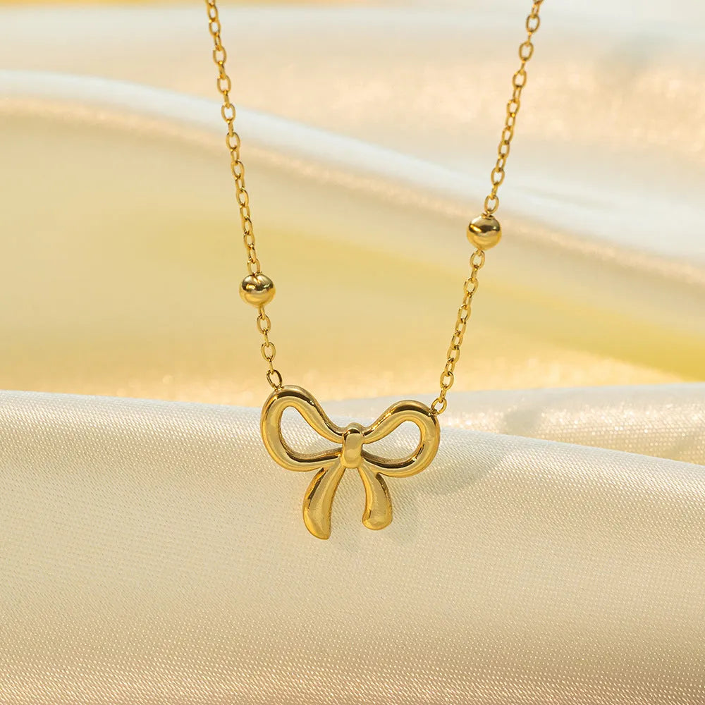 Gold bow necklace with adjustable chain on titanium steel with electroplated finish