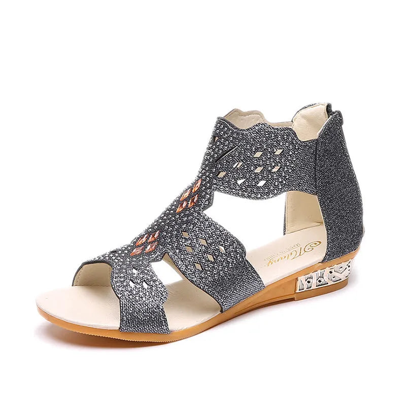 Women's flat open-toe sandals with rhinestone detail and a back zipper in beige, black, and gold.