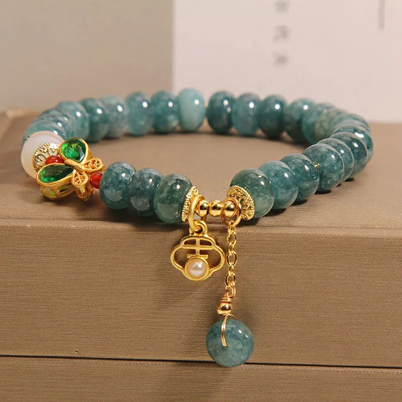 Blue water jade abacus bead and white agate bracelet with alloy and rhinestone details for women.