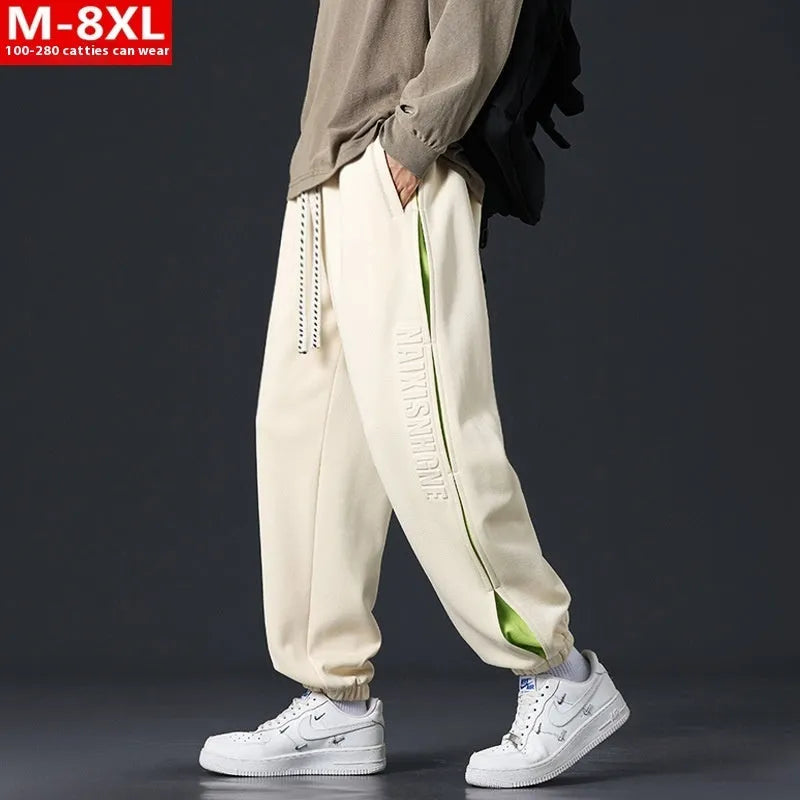 Men's loose fit cotton pants with elasticated ankle bands in grey green colour, showing collage stitching detail.