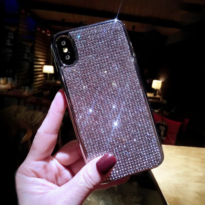 Silver silicone full diamond protective case for iPhone on a table.