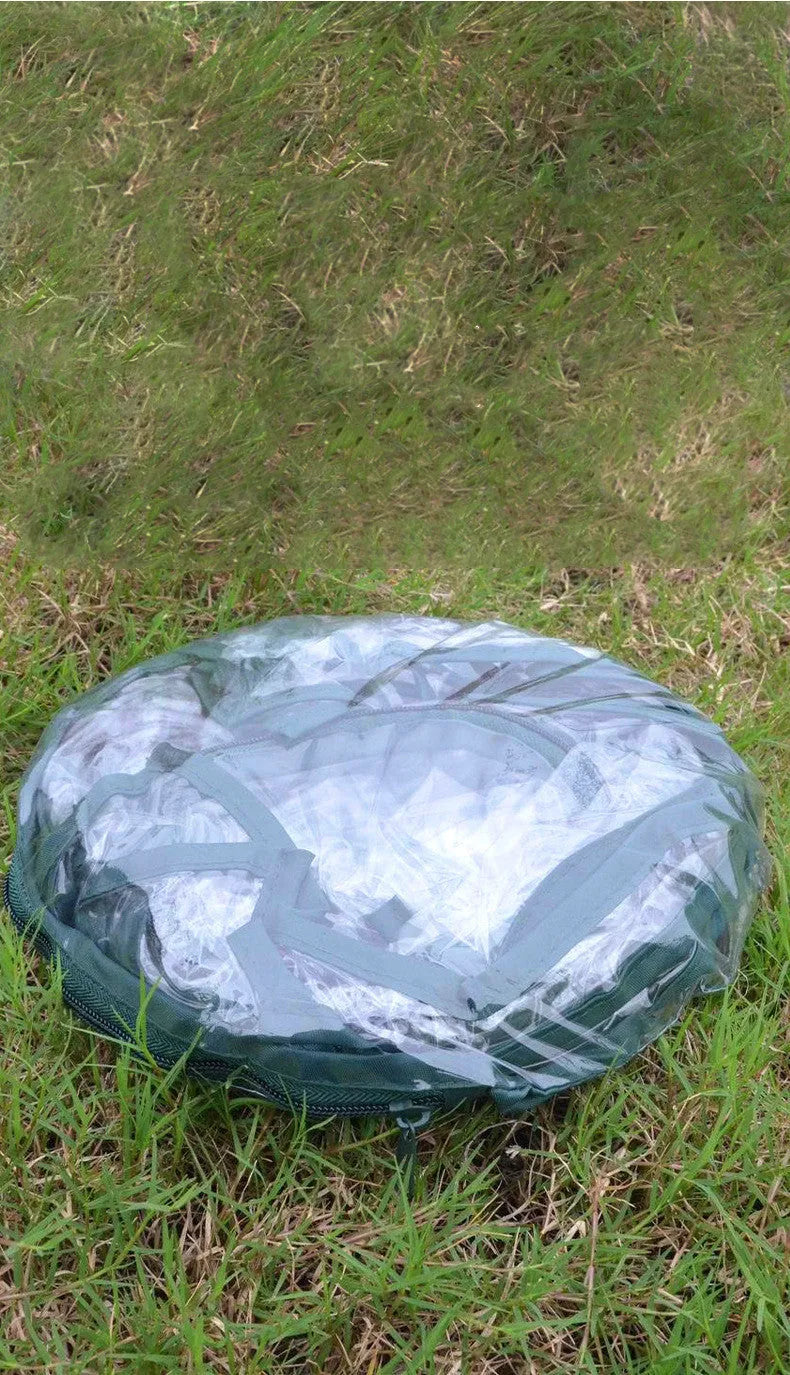 Transparent PVC conservatory tent 90 cm outer size protecting garden plants from frost, with ground nails visible