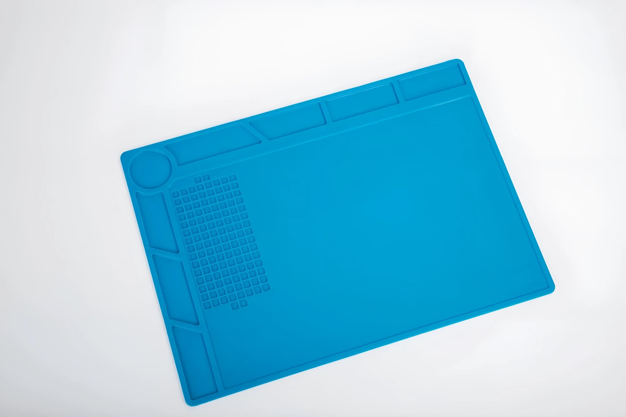 Blue silicone rubber watch repair table mat for anti-skid workspace stabilisation.