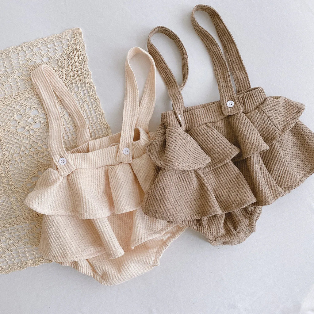 Baby girl romper with pleated lotus leaf design in cotton fabric, showing triangle climb style