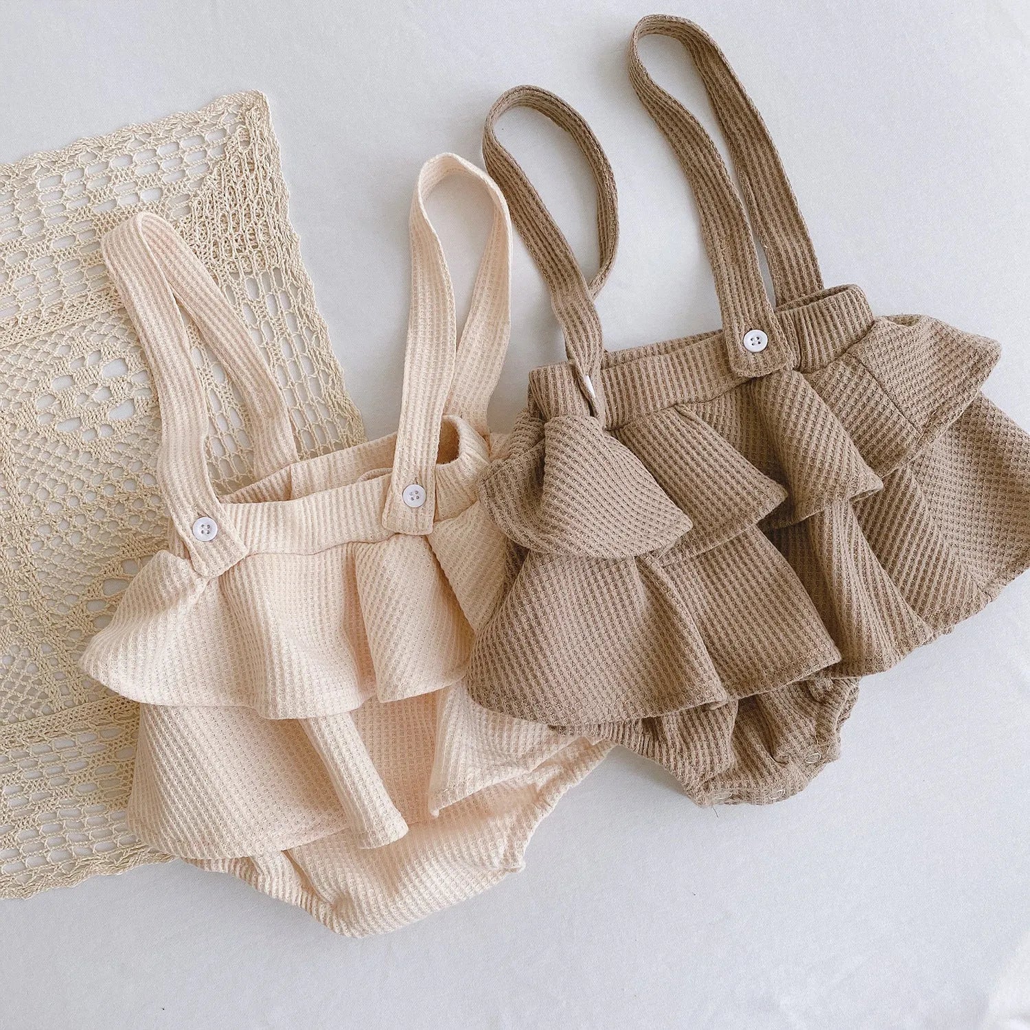 Baby girl romper with pleated lotus leaf design in cotton fabric, showing triangle climb style