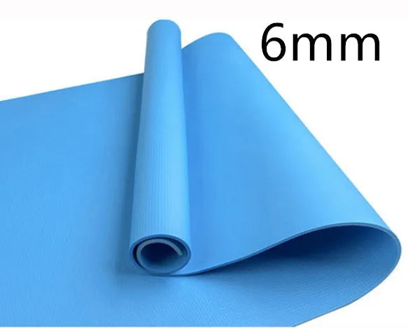 Red EVA fitness yoga mat with rolled edge showing thickness, laid flat on a wooden floor.