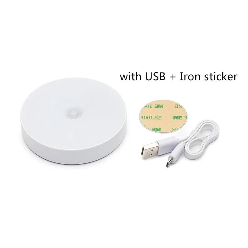 Small white round USB rechargeable motion sensor LED night light with adhesive backing.